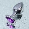 Серебристая коническая анальная пробка с фиолетовым кристаллом-сердечком - 7 см.